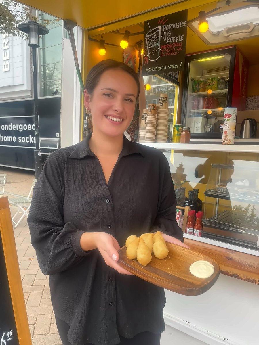 Angela bij haar foodtruck met een plankje vers gefrituurde hapjes
